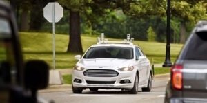 Image of white vehicle driving on the road with various other vehicles