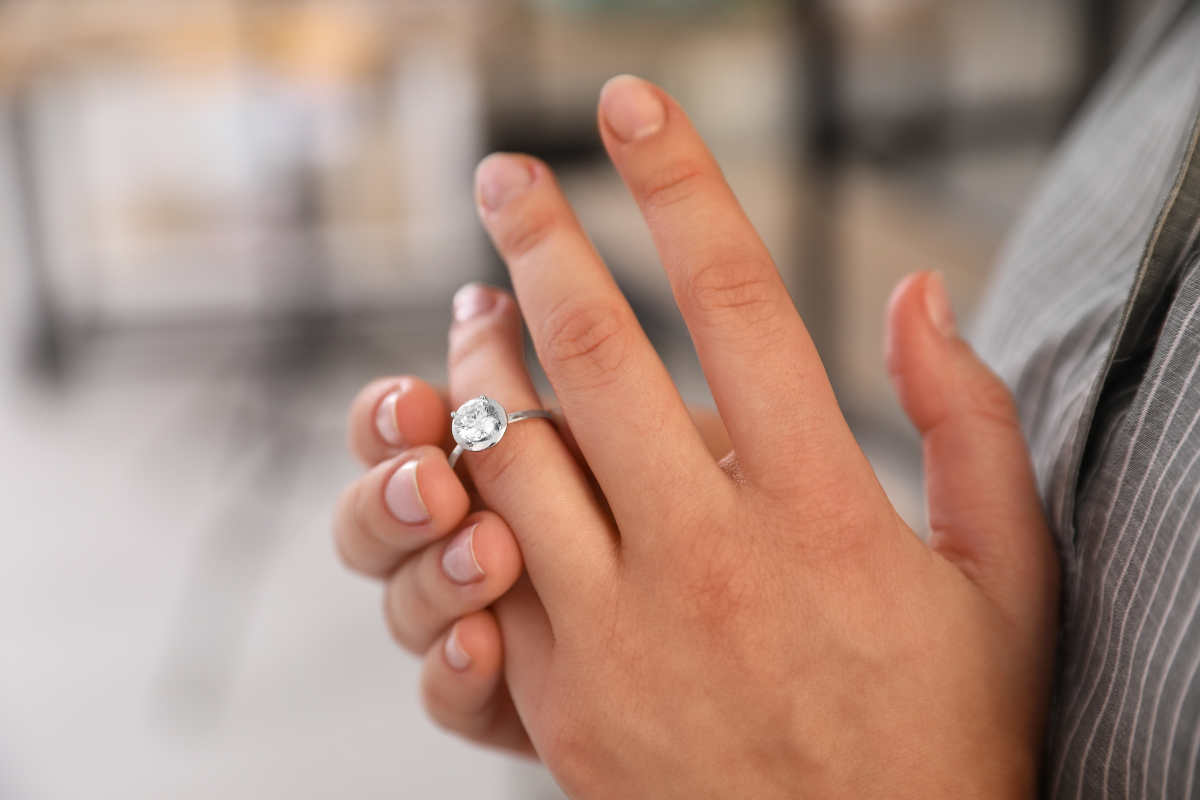 Woman taking ring off her left hand because of a divorce.