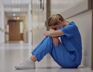 A nurse stressed out from health care wage theft.