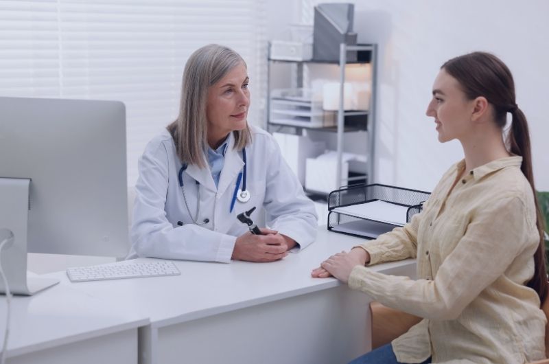 Patient speaking with a healthcare provider during a medical examination, illustrating the importance of recognizing signs of medical sexual abuse.