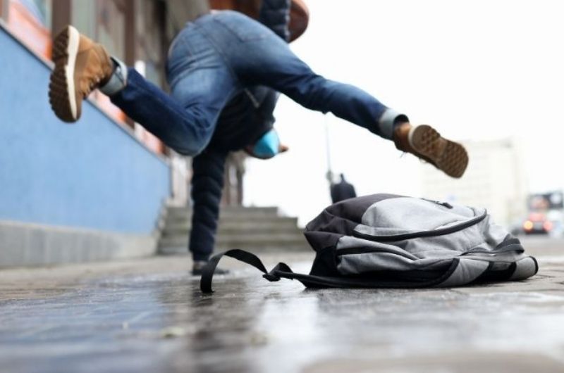 Person slipping on a wet sidewalk outside a commercial building in Austin, Texas.