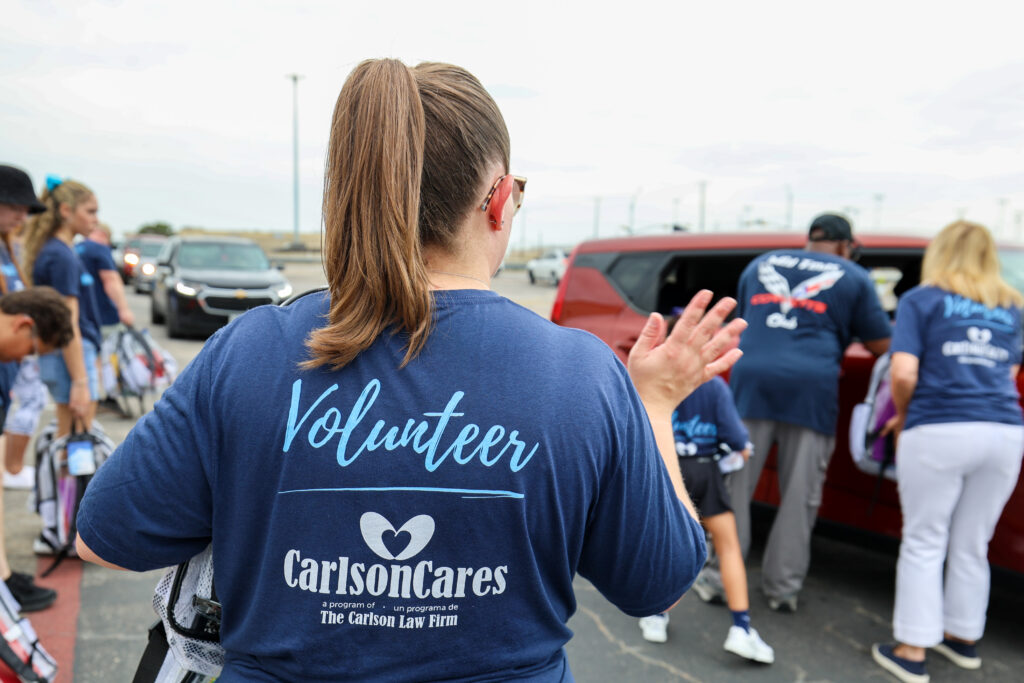 Children and families receive backpacks and school supplies during the 2026 Carlson Cares Killeen Backpack Giveaway.