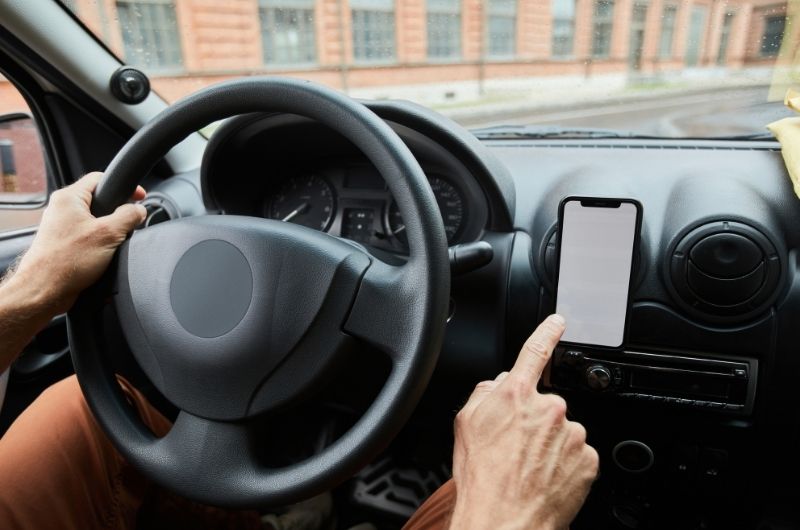 Driver using a cell phone while operating a vehicle in Texas traffic.
