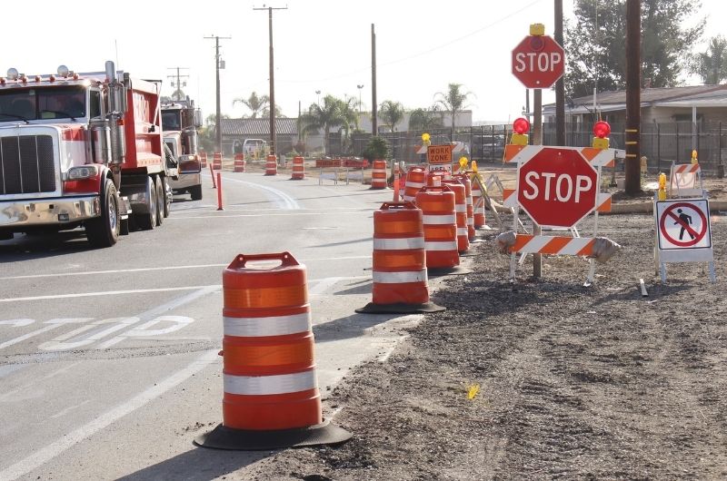 Construction vehicles moving through a highway work zone in Texas.