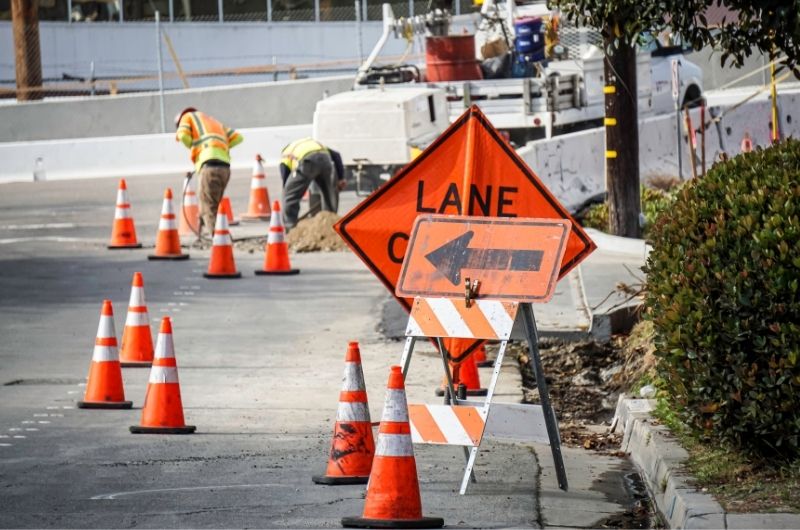 Construction work zone on a Texas highway with orange cones, temporary signage and reduced lanes.