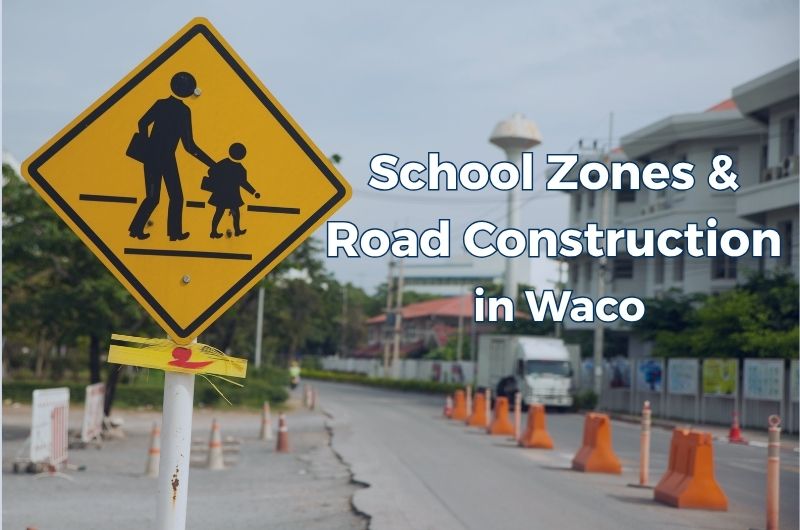 A Waco school zone near a pedestrian crossing and road construction barriers.
