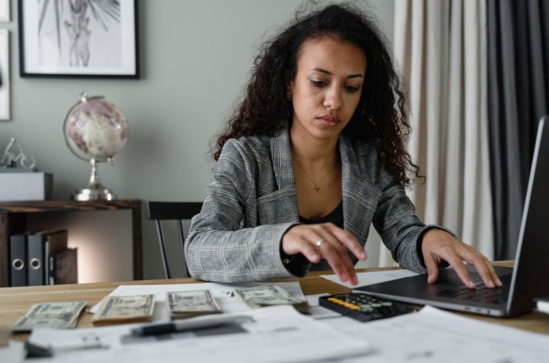 Worker using a calculator while reviewing pay and financial records