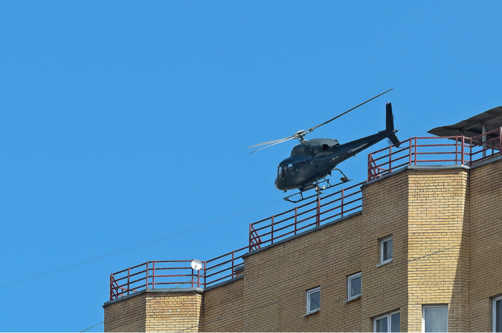Helicopter flying at low altitude near a building.