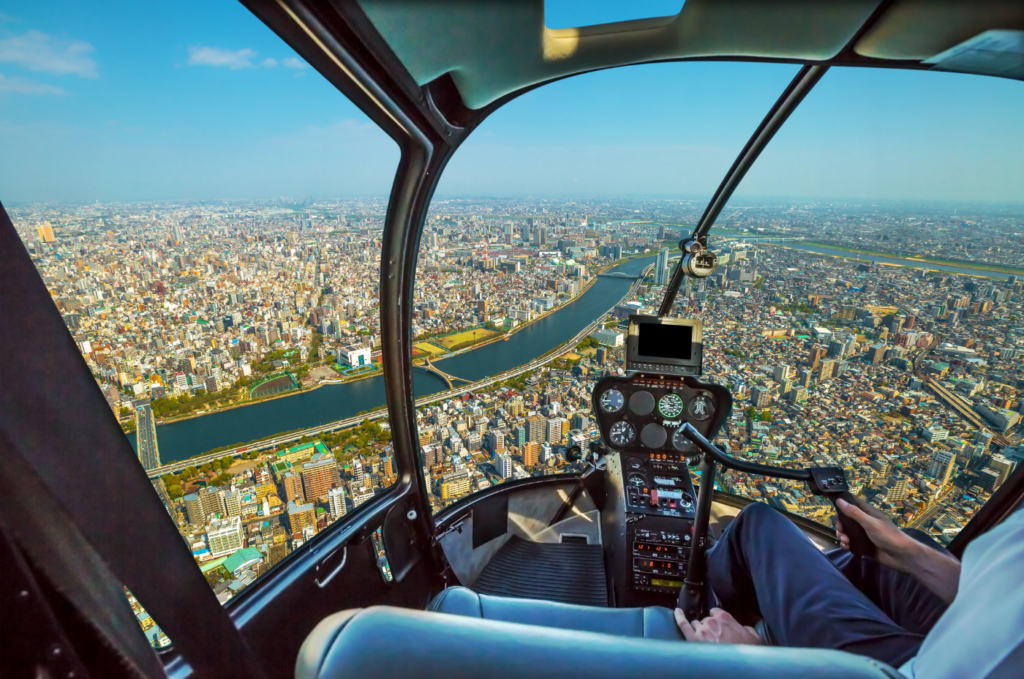 View of a city from inside a helicopter cockpit.