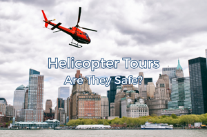 Red helicopter flying above a city skyline.