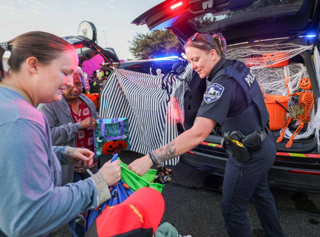 Temple police officer hands out candy at the 2026 Carlson Cares Trunk or Treat