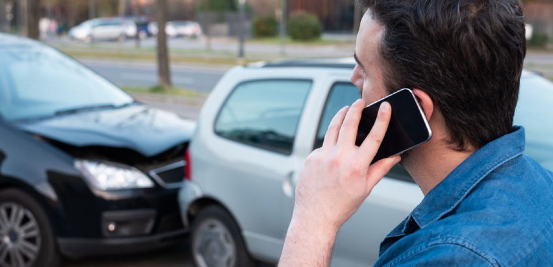 Man calling roadside emergency after car accident