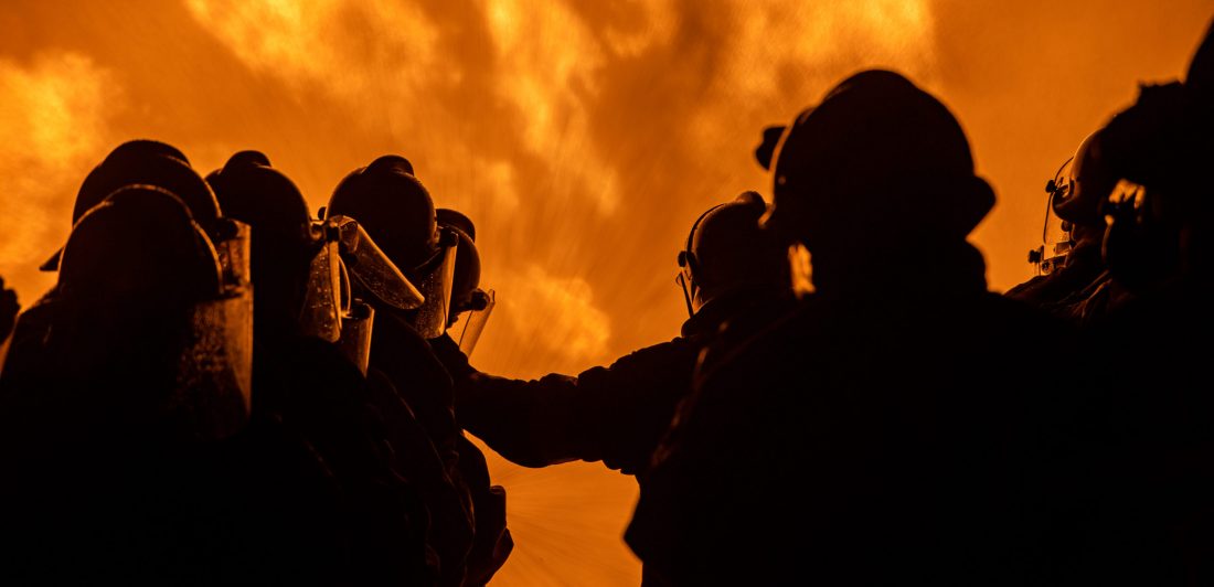 131654890_l-scaled Image of firefighters standing in front of a large fire