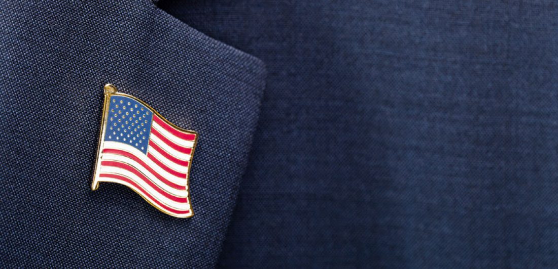 Element of male suit with USA flag pin on chest – studio shot Image of suit lapel with flag pin