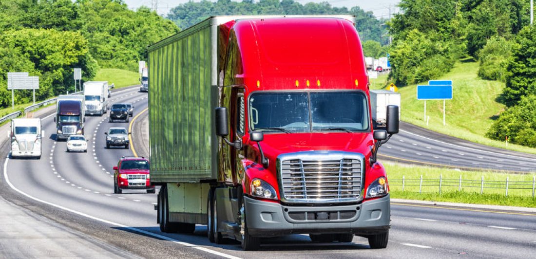 Red Semi Truck on Interstate Highway Image of a red semi on the highway with other vehicles