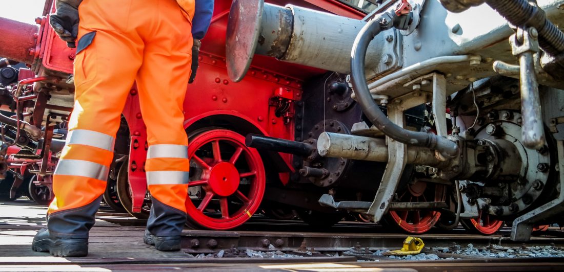 Railway worker in action Image of a railway worker in safety gear standing by a train
