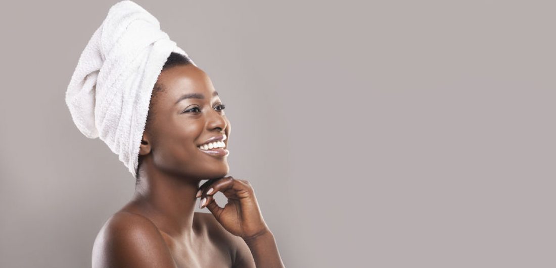 Beautiful african woman with towel on head and glowing skin Image of woman in with a towel wrapped around her body and a towel on her head