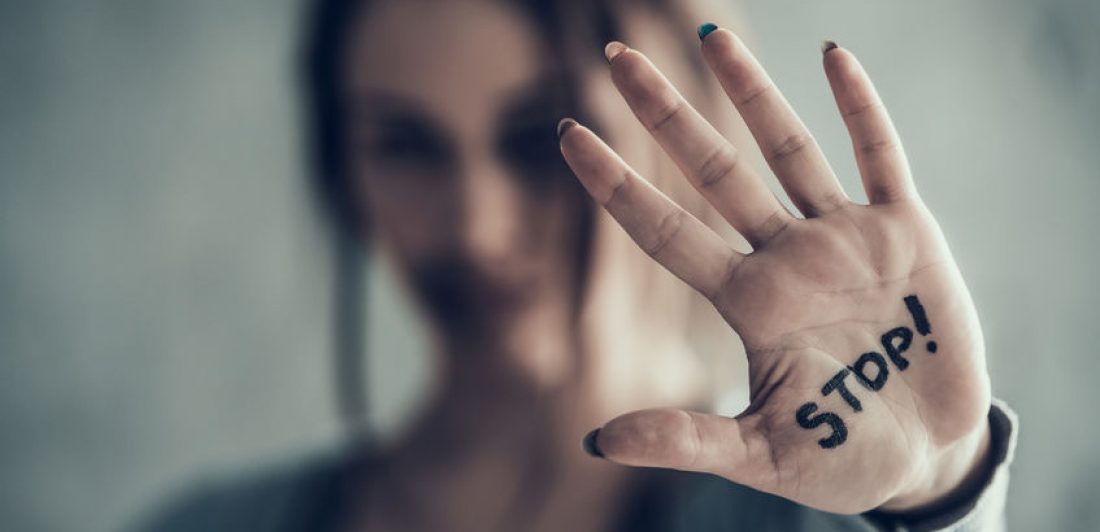 Oppressed woman shows by hand sign stop. Bruises on face. Image of woman holding her hand up with the word stop! written on her palm