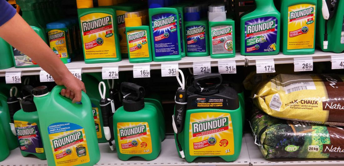 SAMSUNG CSC Image of person taking a container of Round Up off a store shelf