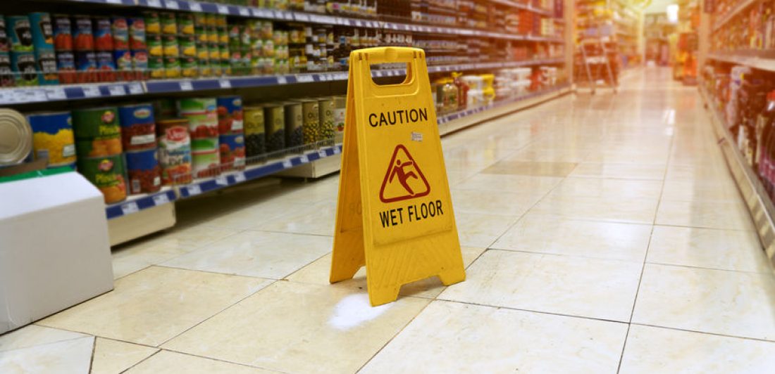 Yellow sign – caution wet floor Image of grocery store isle with caution wet floor sign