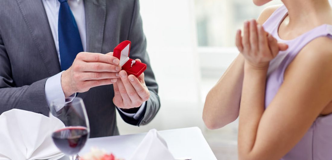 excited young woman and boyfriend giving her ring Image of man proposing to a woman at dinner