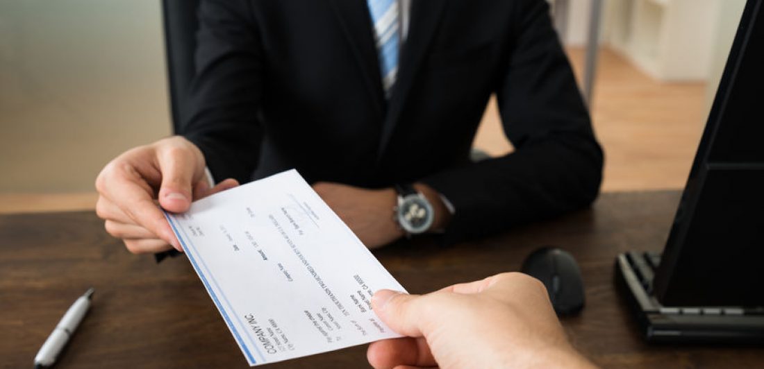 Businessman Giving Cheque To Other Person Image of two people exchanging a check