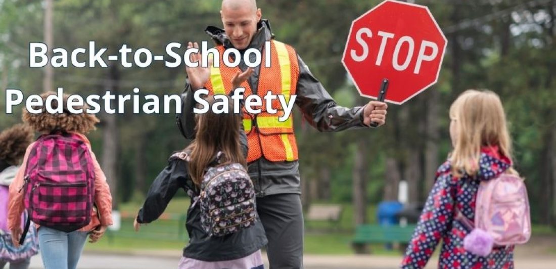 School crossing guard helping elementary school children safely cross the street during the morning commute.