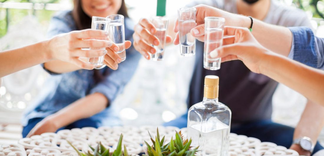 Friends drinking tequila shots outdoors Image of people doing shots