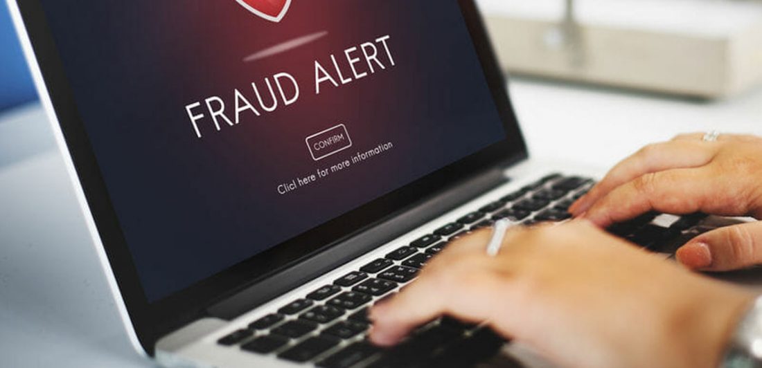 Image of person with fraud alert displayed on their laptop screen