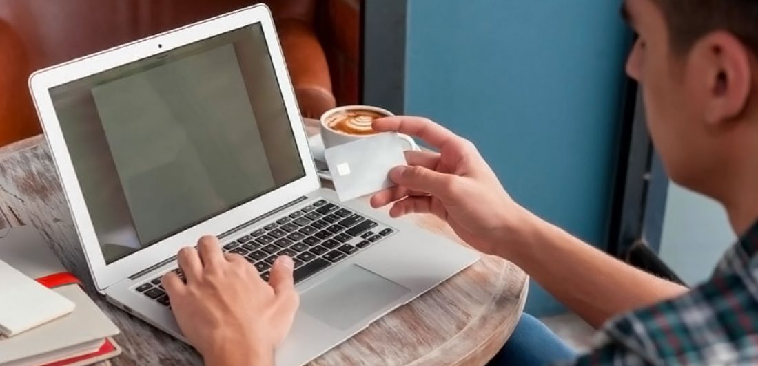 post-bankruptcy-affect-employment Image of man with a cup of coffee making an online payment on his laptop