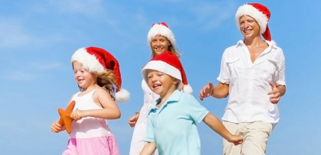post-christmas-vacation-travel-tips Image of family with two small children wearing santa hats