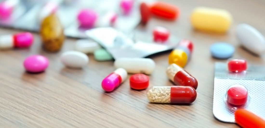 post-fda-drug-approval-process Image of various colorful pills in blister packs and loose on the table