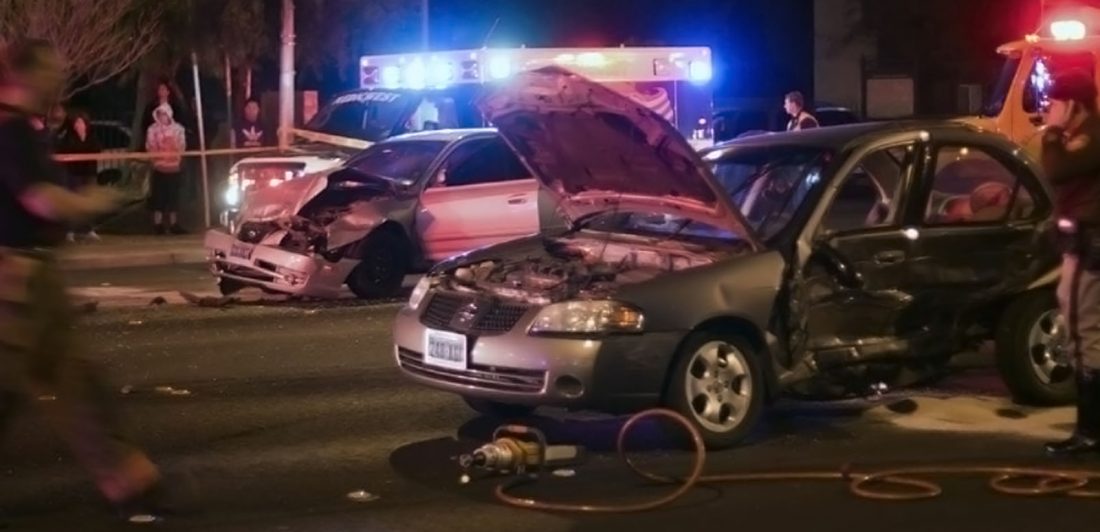 post-labor-day-car-crash-fatalities Image of a multi-car accident at night with onlookers and emergency personel