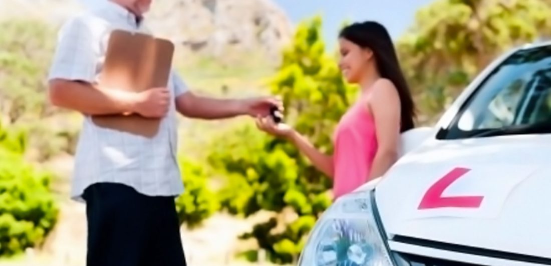 Image of a person handing kets to a teen driver next to a car