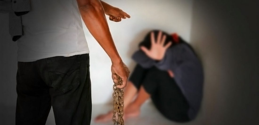 post-romeo-pimp Image of man holding a chain pointing at a scared woman in a corner who is covering her face and holding up her hand
