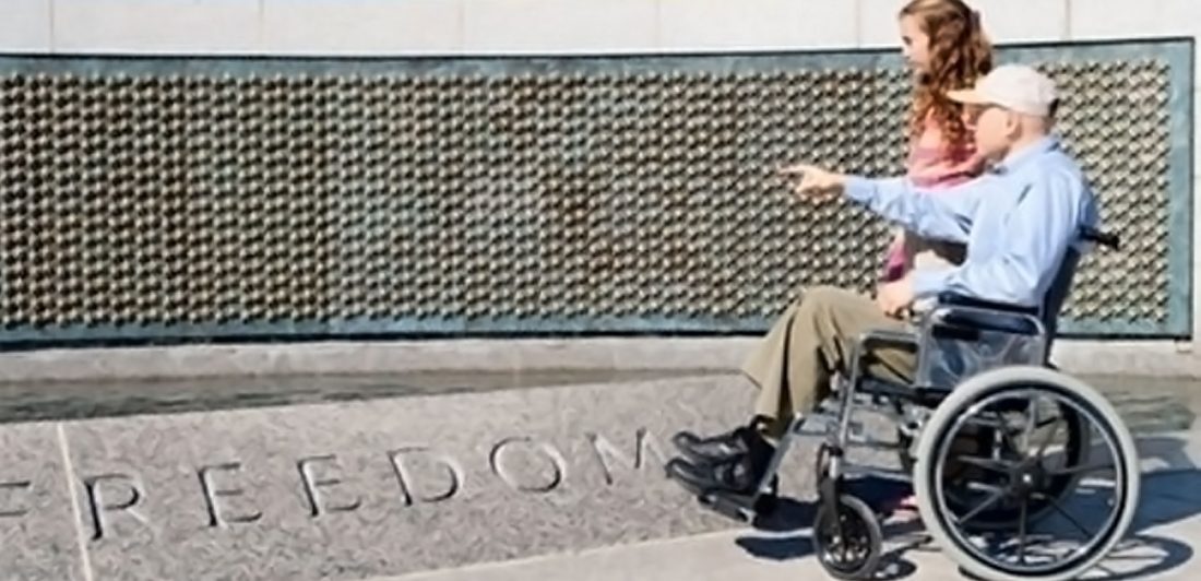 post-veterans-mesothelioma-deaths Image of a veteran in a wheelchair visiting a war memorial with a young girl