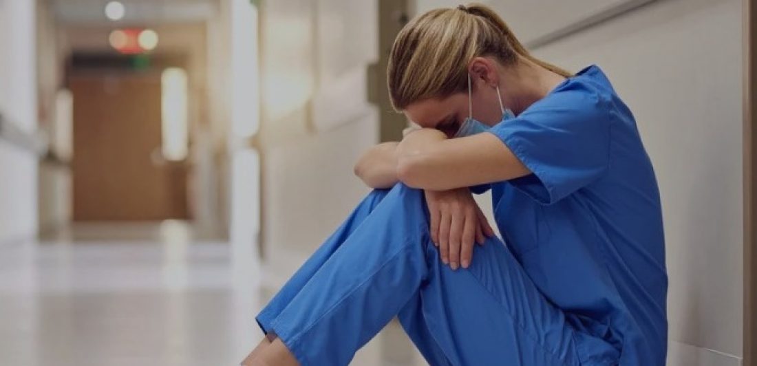 A nurse stressed out from health care wage theft.