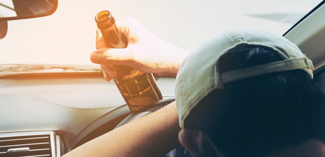 teen-drunk-driving Man in vehicle holding a beer bottle