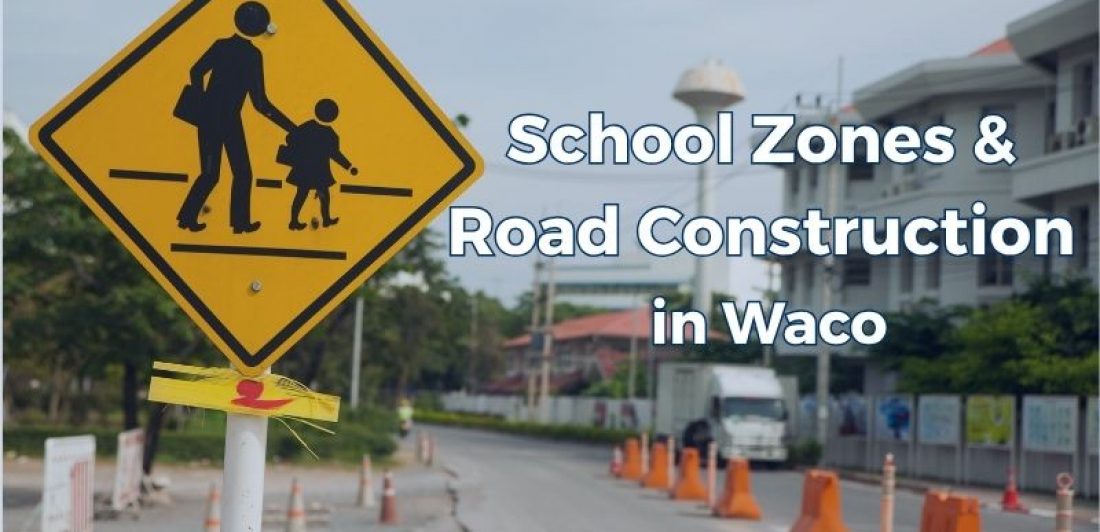 A Waco school zone near a pedestrian crossing and road construction barriers.